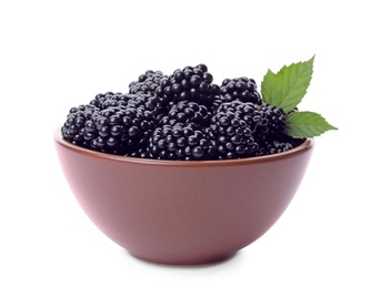 Brown bowl of tasty ripe blackberries with leaves on white background