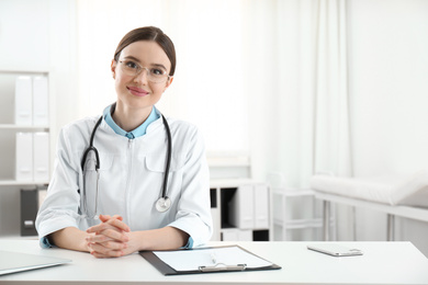 Photo of Portrait of young female doctor in white coat at workplace