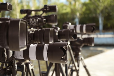 Modern professional video cameras outdoors on sunny day, closeup