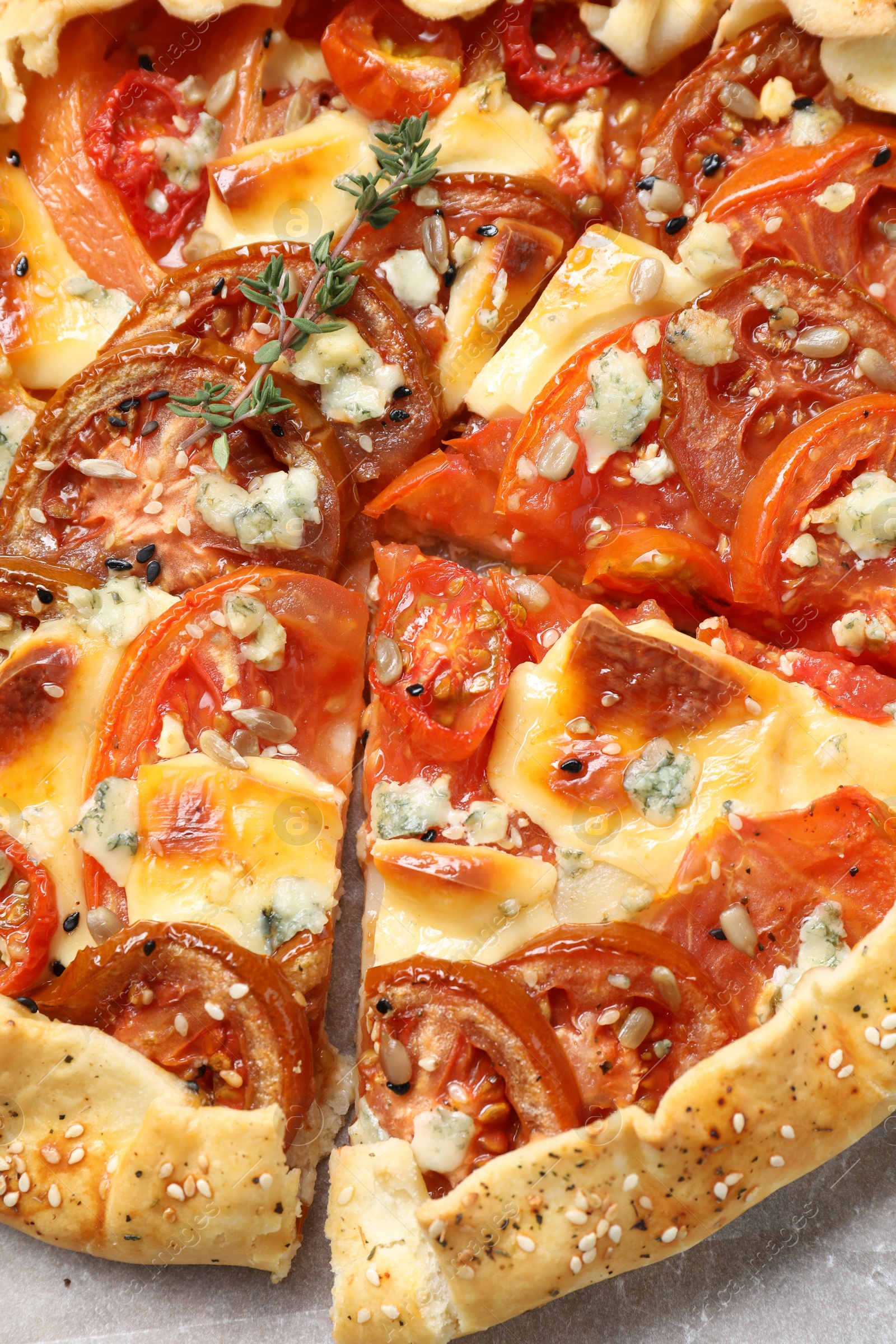 Photo of Tasty galette with tomato and cheese (Caprese galette) on parchment, top view