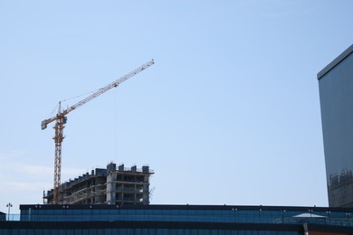 Construction site with tower crane near unfinished building