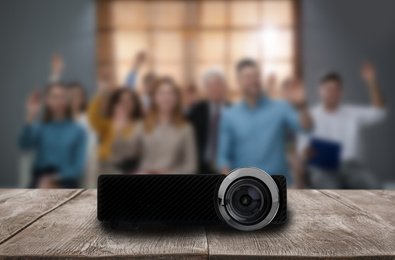 Image of Modern video projector and blurred people on background