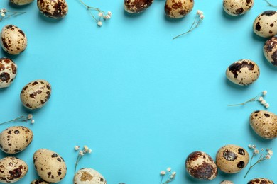 Photo of Frame made of speckled quail eggs on light blue background, flat lay. Space for text