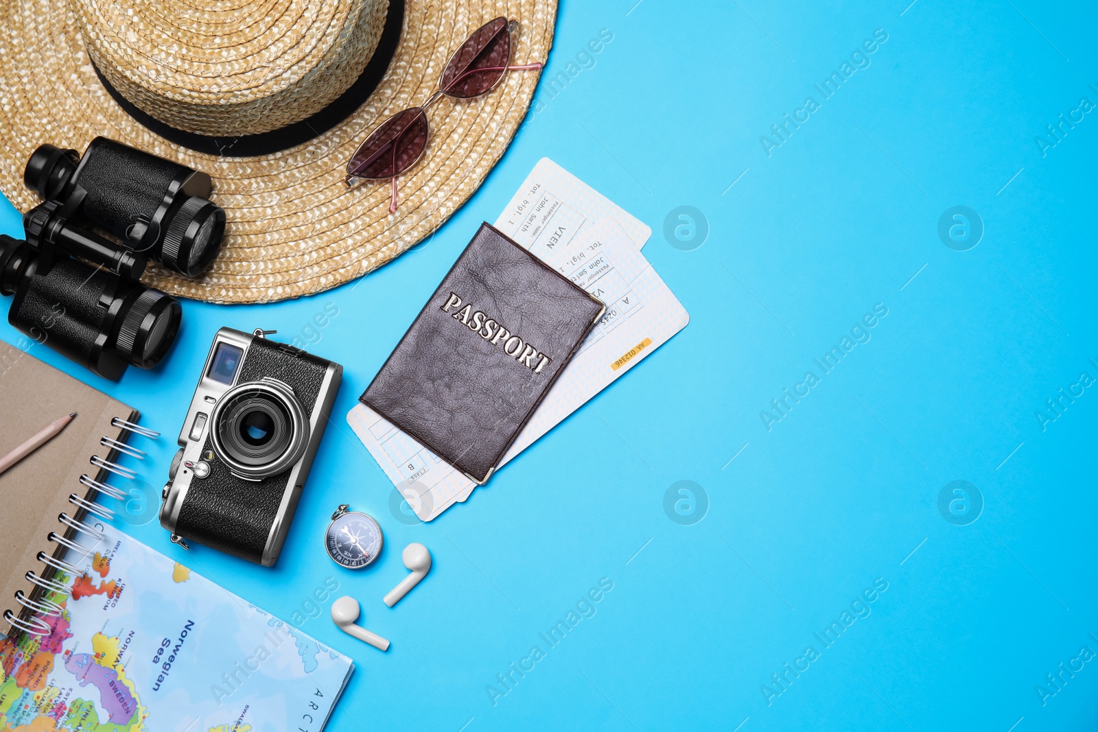 Photo of Flat lay composition with passport, tickets and holiday items on light blue background. Space for text