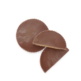 Photo of Cut and whole delicious peanut butter cups on white background, top view