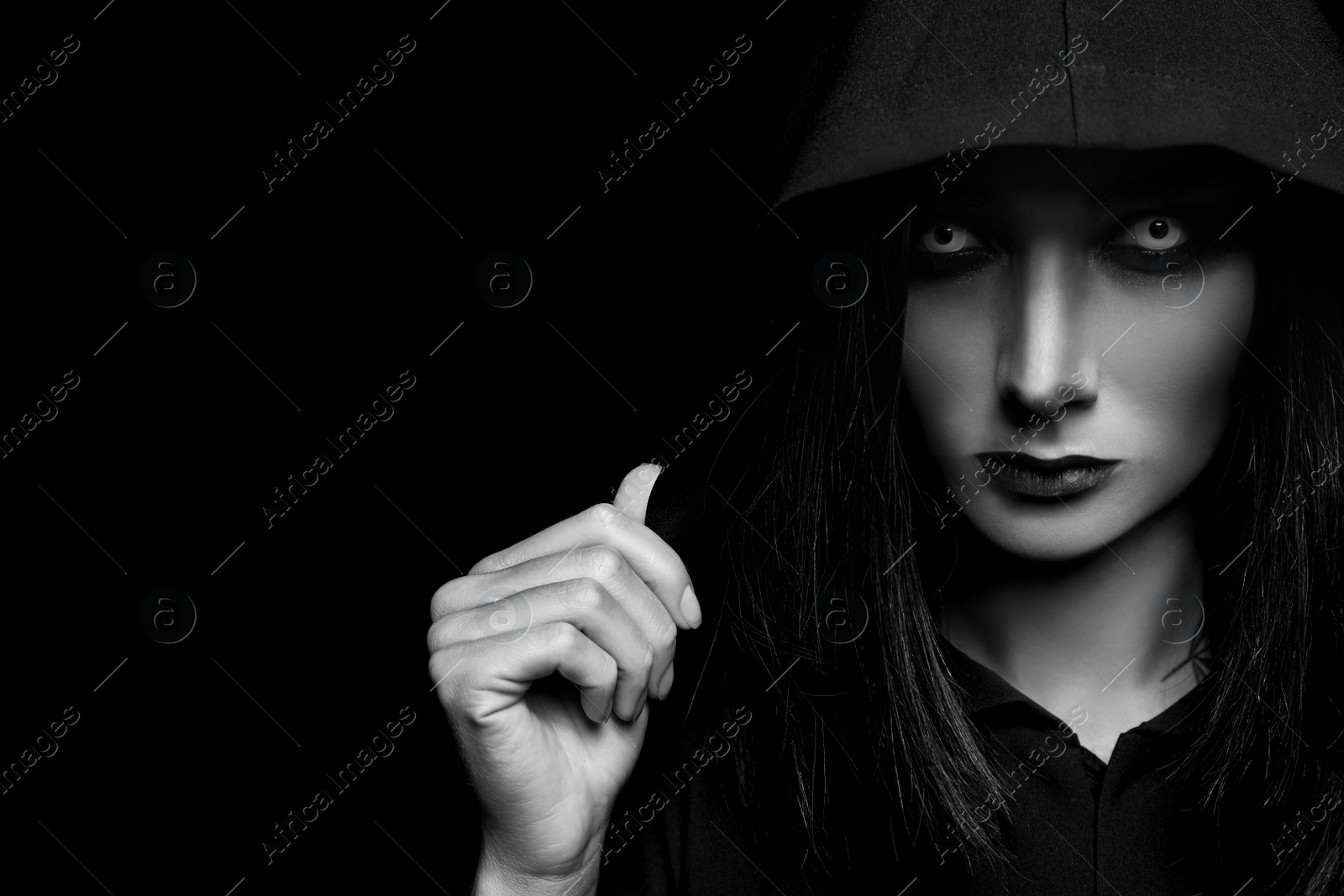 Photo of Mysterious witch with spooky eyes on dark background, space for text. Black and white effect