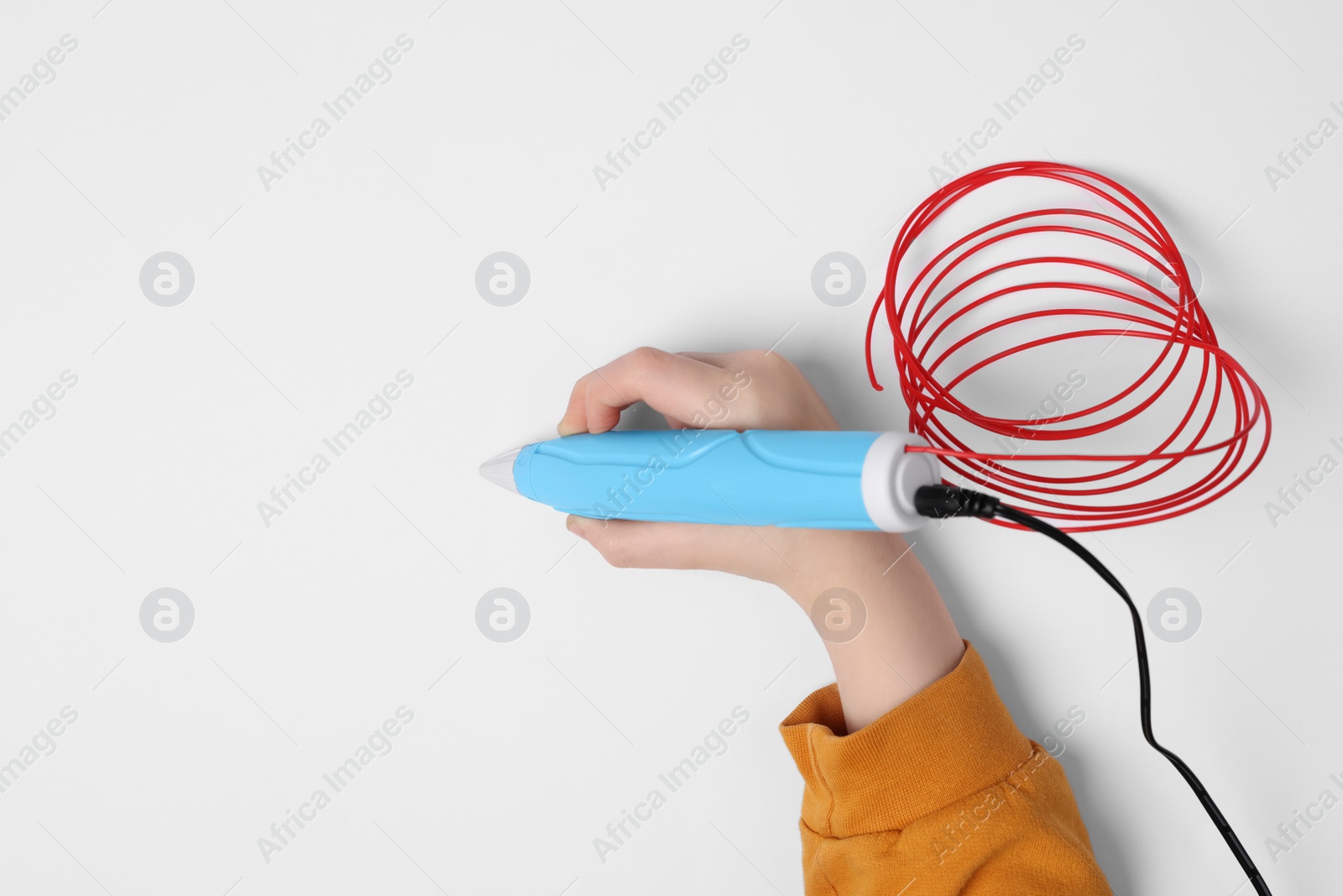 Photo of Boy drawing with stylish 3D pen on white background, top view. Space for text