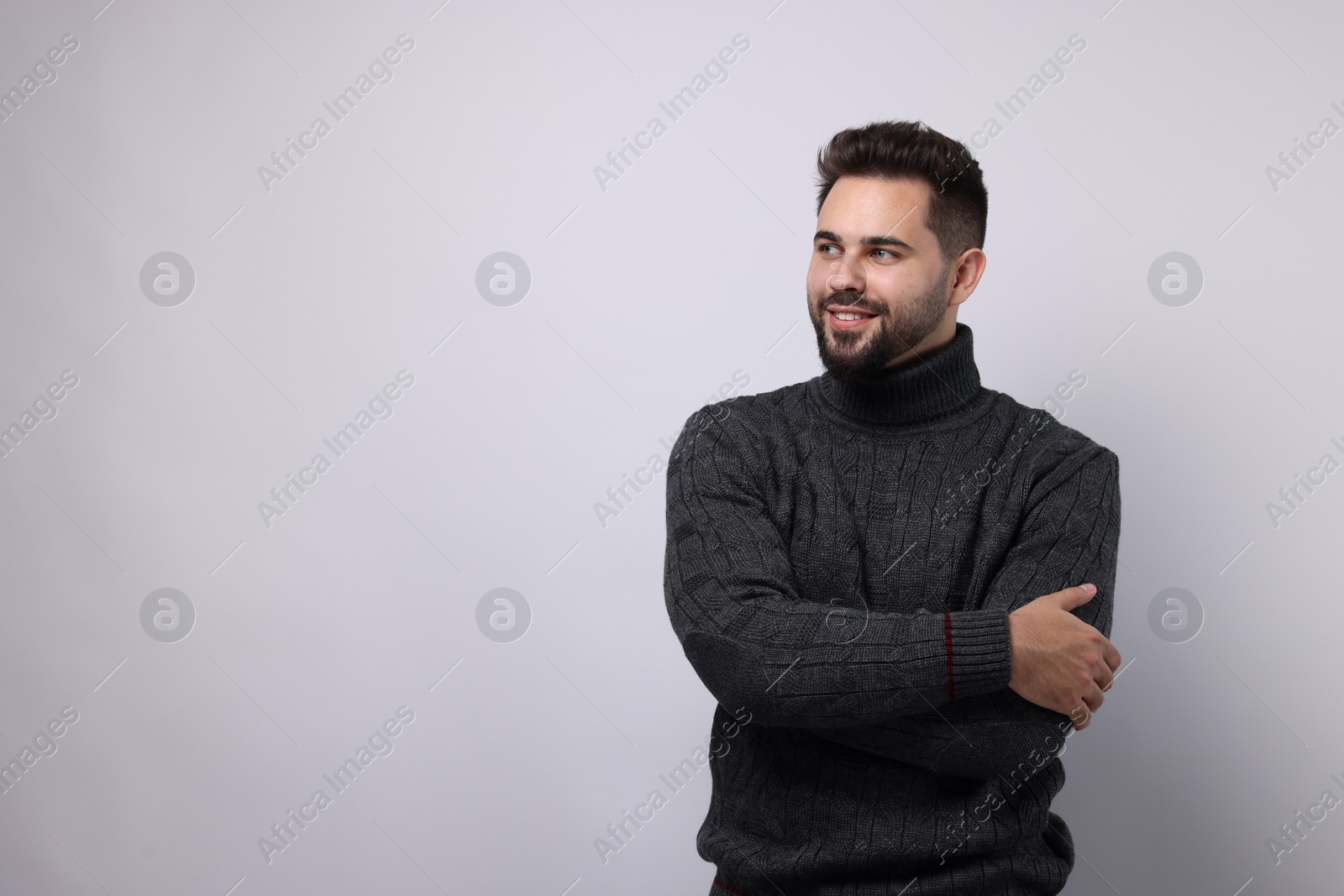 Photo of Happy man in stylish sweater on white background, space for text