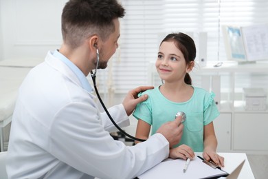 Pediatrician examining little girl in office at hospital