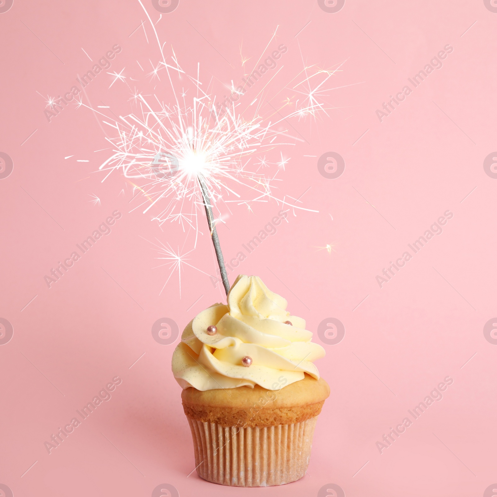 Image of Birthday cupcake with sparkler on pink background