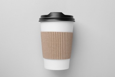 Photo of One paper cup on light grey background, top view. Coffee to go