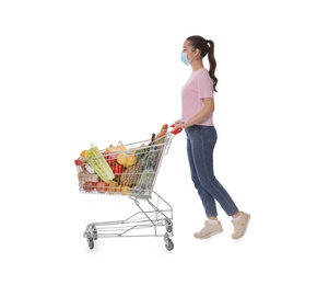 Photo of Woman with protective mask and shopping cart full of groceries on white background