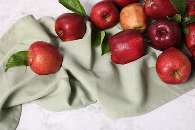 Photo of Ripe red apples with leaves and water drops on white marble table