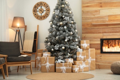 Photo of Stylish room interior with beautiful Christmas tree and gift boxes
