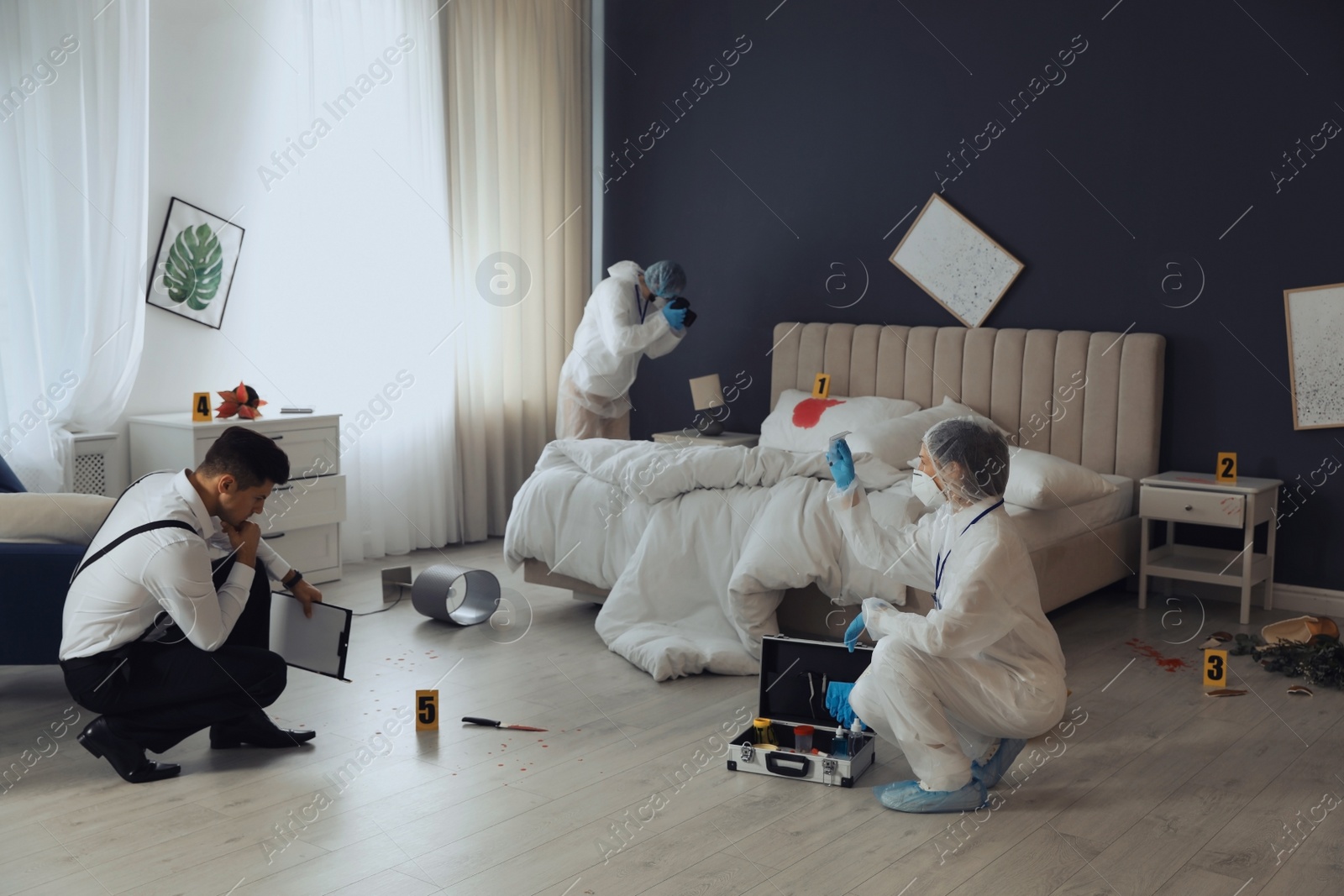 Photo of Investigators working at crime scene in messy room