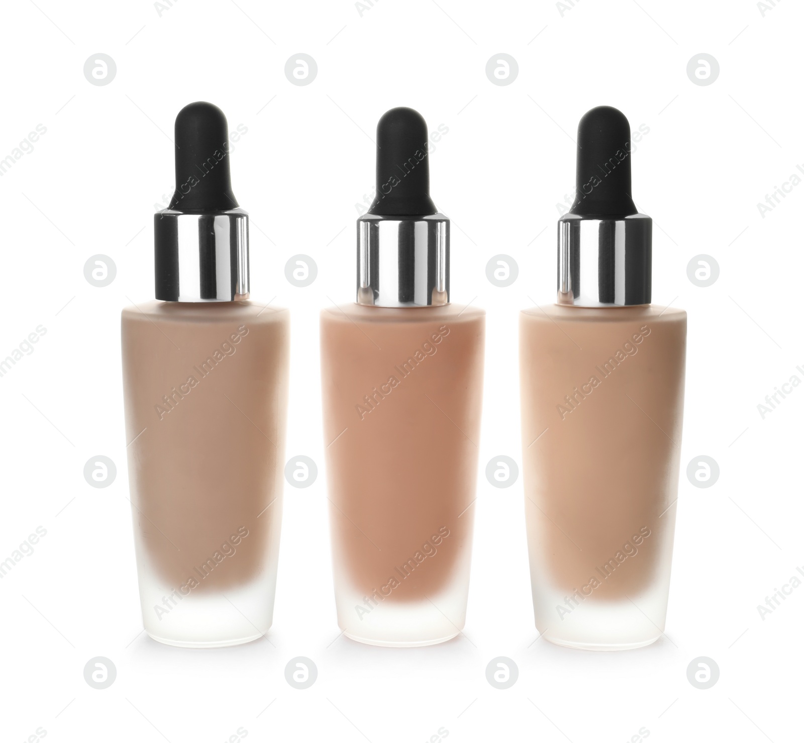 Photo of Bottles of different skin foundations on white background