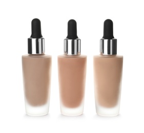 Photo of Bottles of different skin foundations on white background