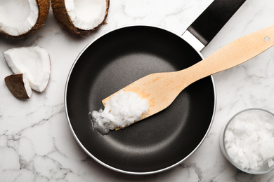 Photo of Flat lay composition with coconut oil and frying pan on white marble table. Healthy cooking