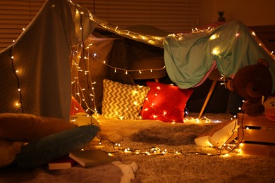 Photo of Beautiful play tent decorated with festive lights at home