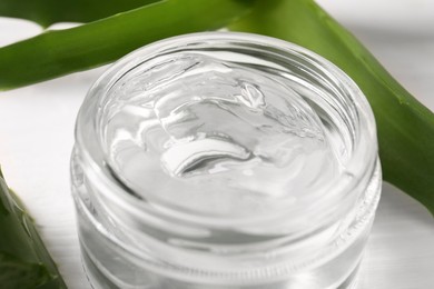 Photo of Jar of natural aloe gel on table, closeup