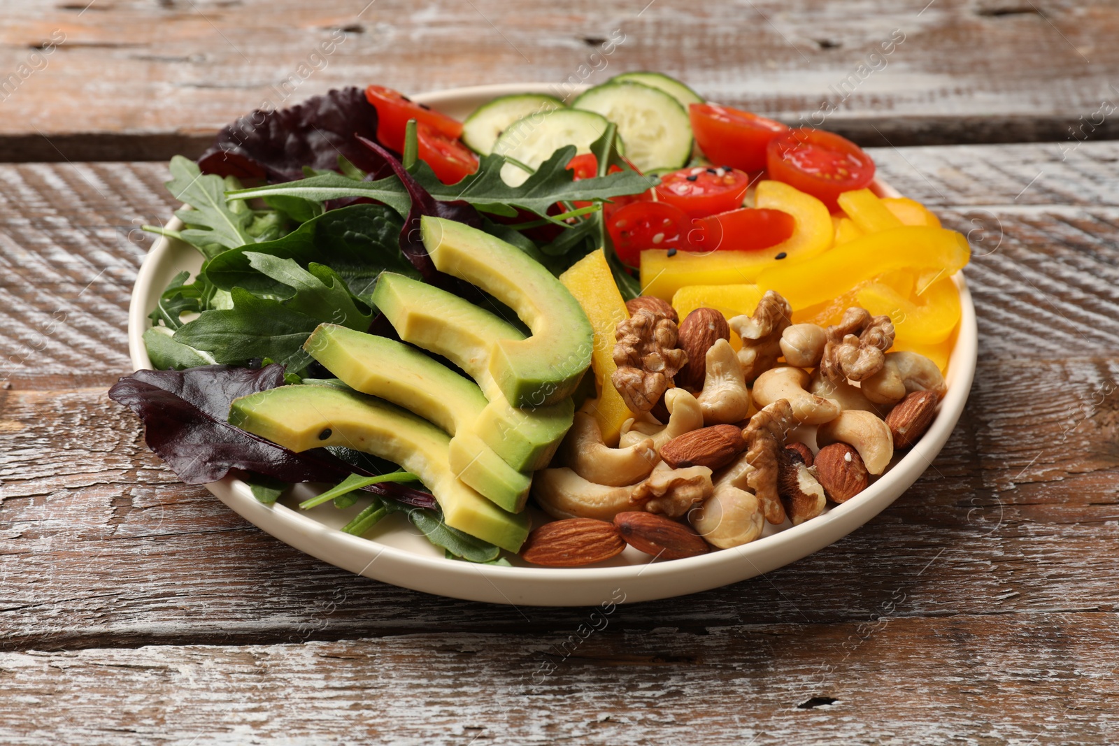 Photo of Balanced diet and vegetarian foods. Plate with different delicious products on wooden table, closeup