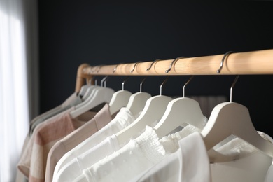 Photo of Different stylish clothes on rack indoors, closeup