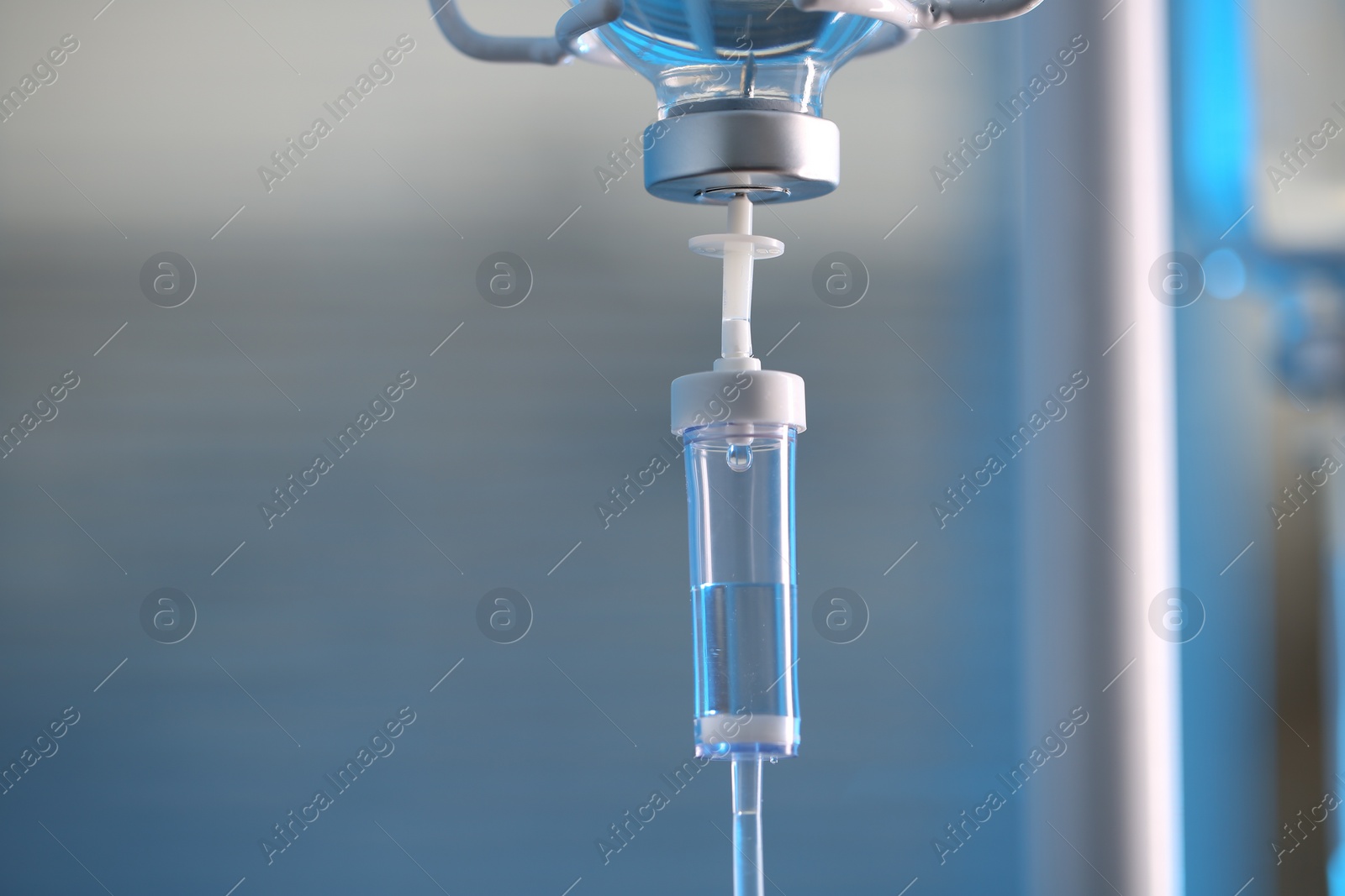 Photo of IV drip chamber against blurred light background