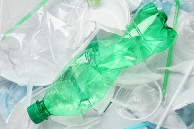 Photo of Pile of different plastic items as background, top view