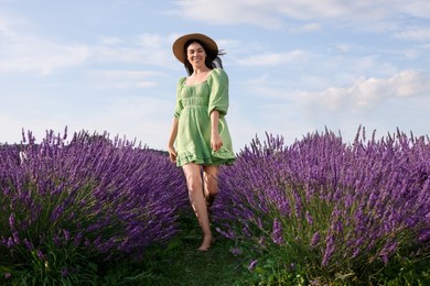 Photo of Happy woman wearing hat in lavender field