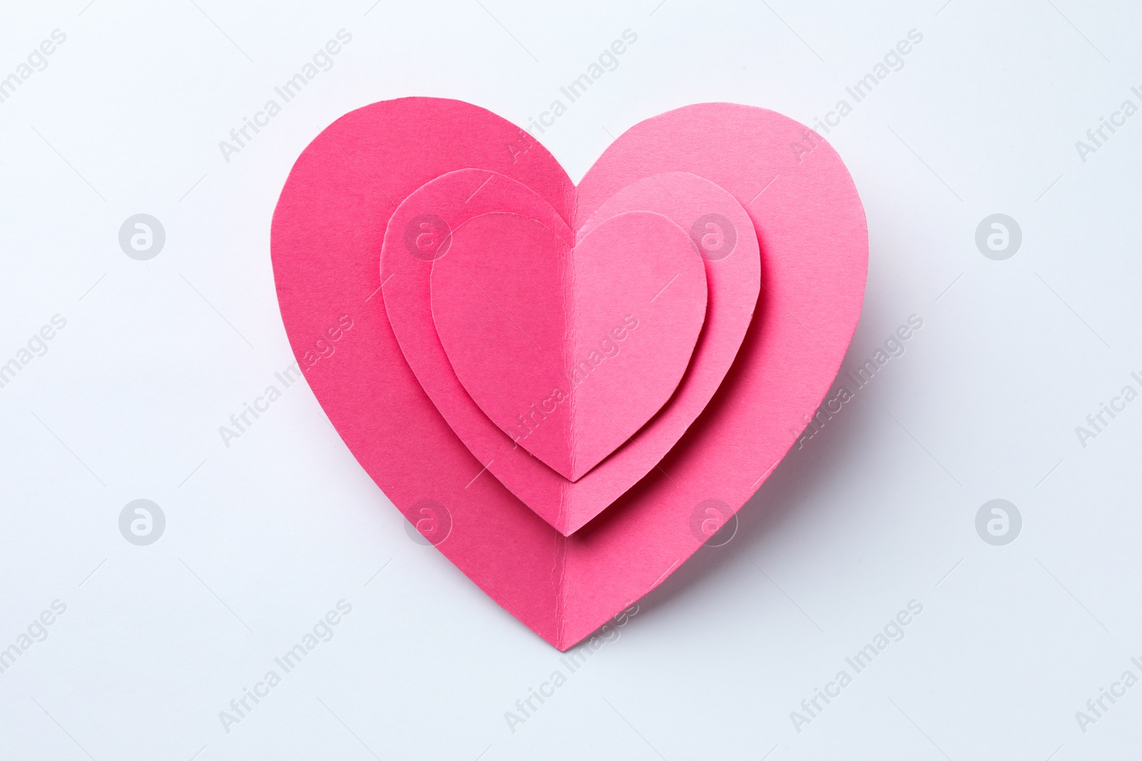 Photo of Pink paper hearts on white background, top view