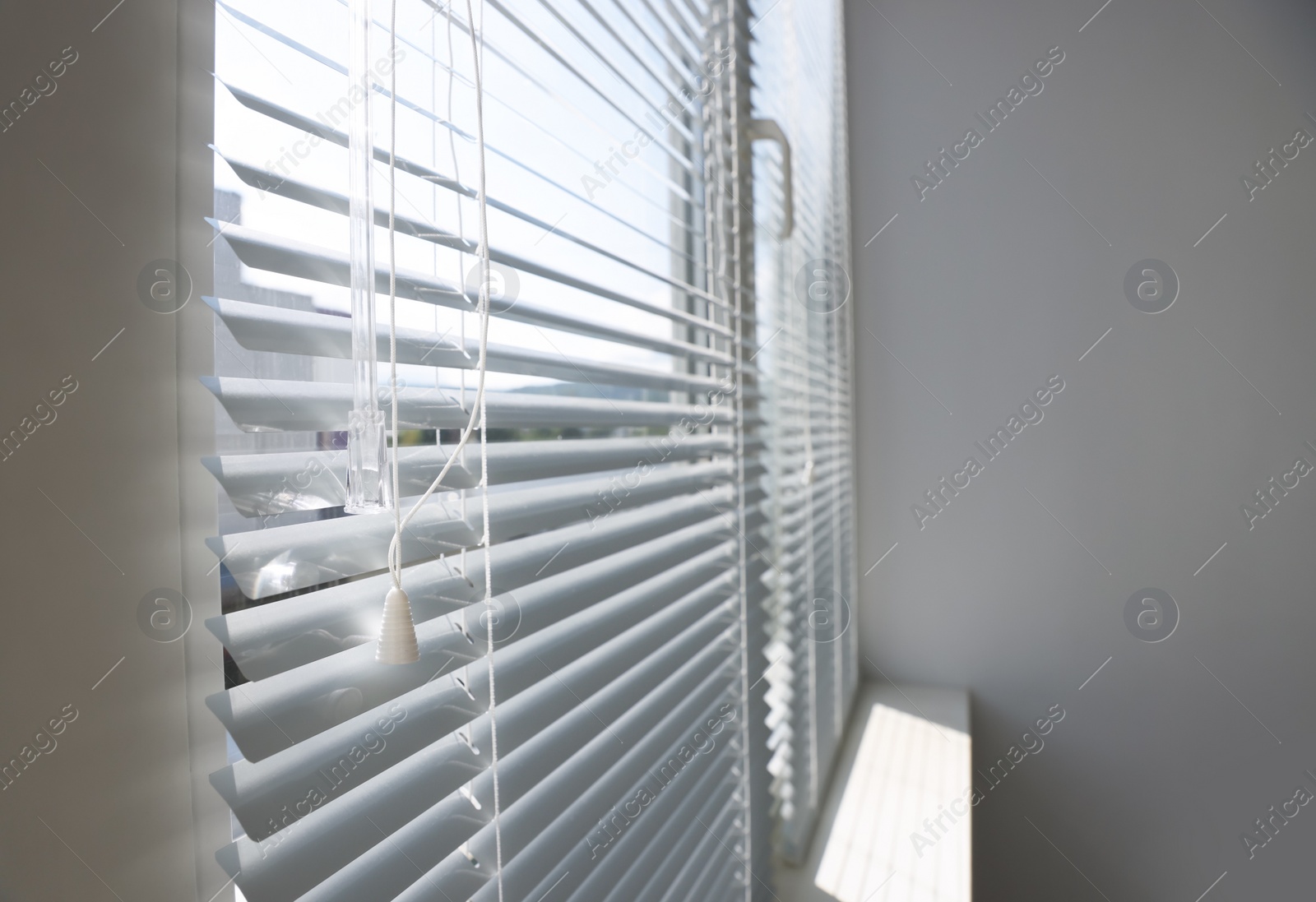 Photo of Stylish window with horizontal blinds in room