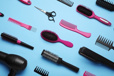 Photo of Flat lay composition of professional hairdresser tools on light blue background