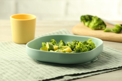 Pieces of boiled broccoli and squash on grey table, space for text. Child's food