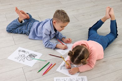 Cute little children coloring on warm floor at home. Heating system