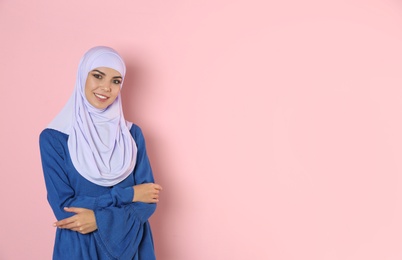 Photo of Portrait of young Muslim woman in hijab against color background. Space for text