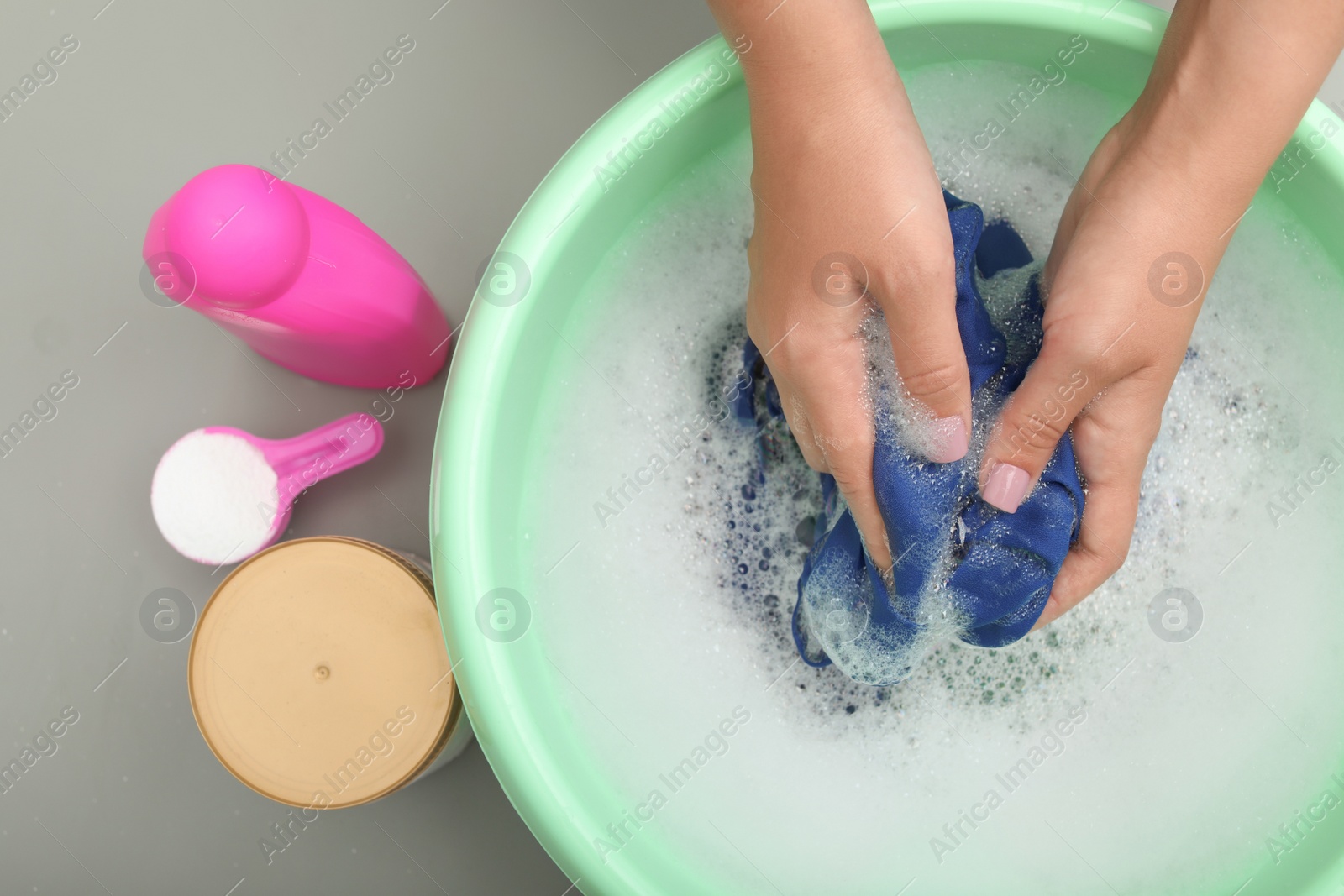 Photo of Woman washing color clothes in basin, closeup