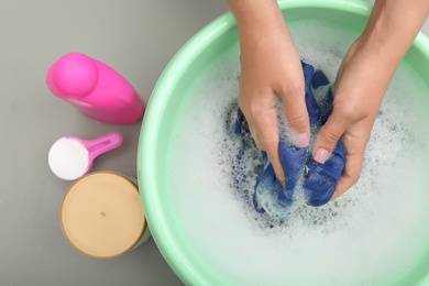 Photo of Woman washing color clothes in basin, closeup