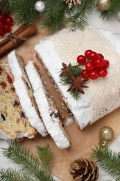 Photo of Traditional Christmas Stollen with icing sugar on white table, flat lay