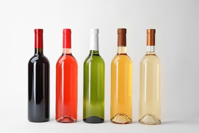 Photo of Bottles of expensive wines on light background
