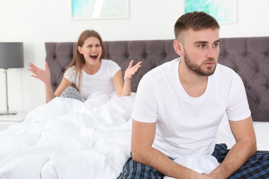 Photo of Young couple arguing in bedroom. Relationship problems