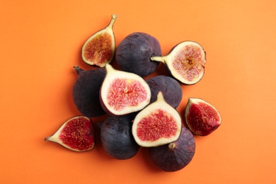 Photo of Delicious ripe figs on orange background, flat lay