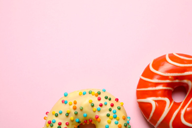 Photo of Delicious glazed donuts on pink background, flat lay. Space for text