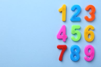 Colorful numbers on blue background, flat lay. Space for text