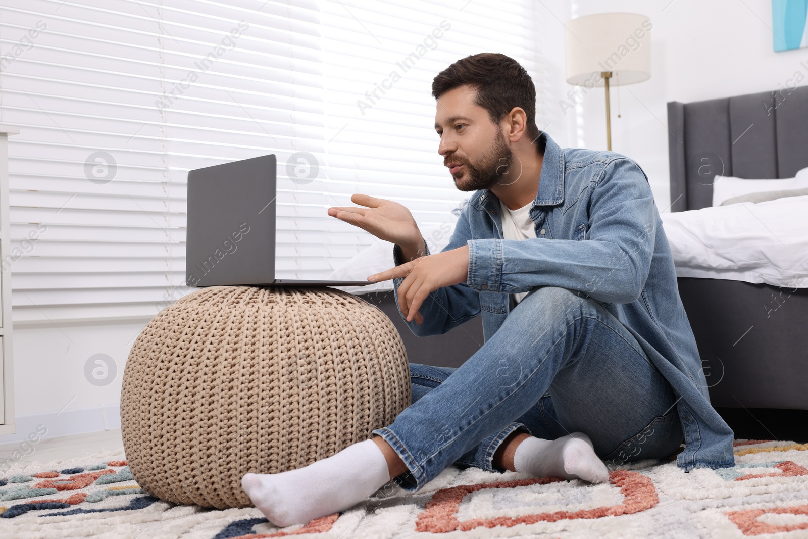 Photo of Man blowing kiss during video chat via laptop at home. Long-distance relationship