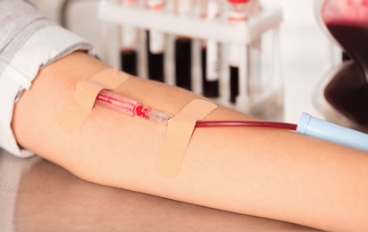 Photo of Woman making blood donation at hospital, closeup