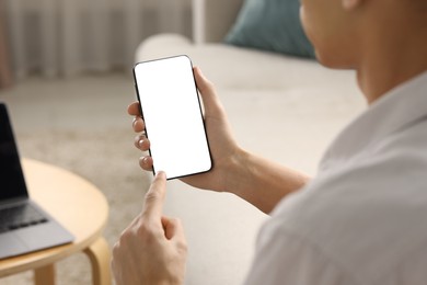 Photo of Man using smartphone with blank screen indoors, closeup. Mockup for design