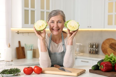 Happy housewife cooking at table in kitchen