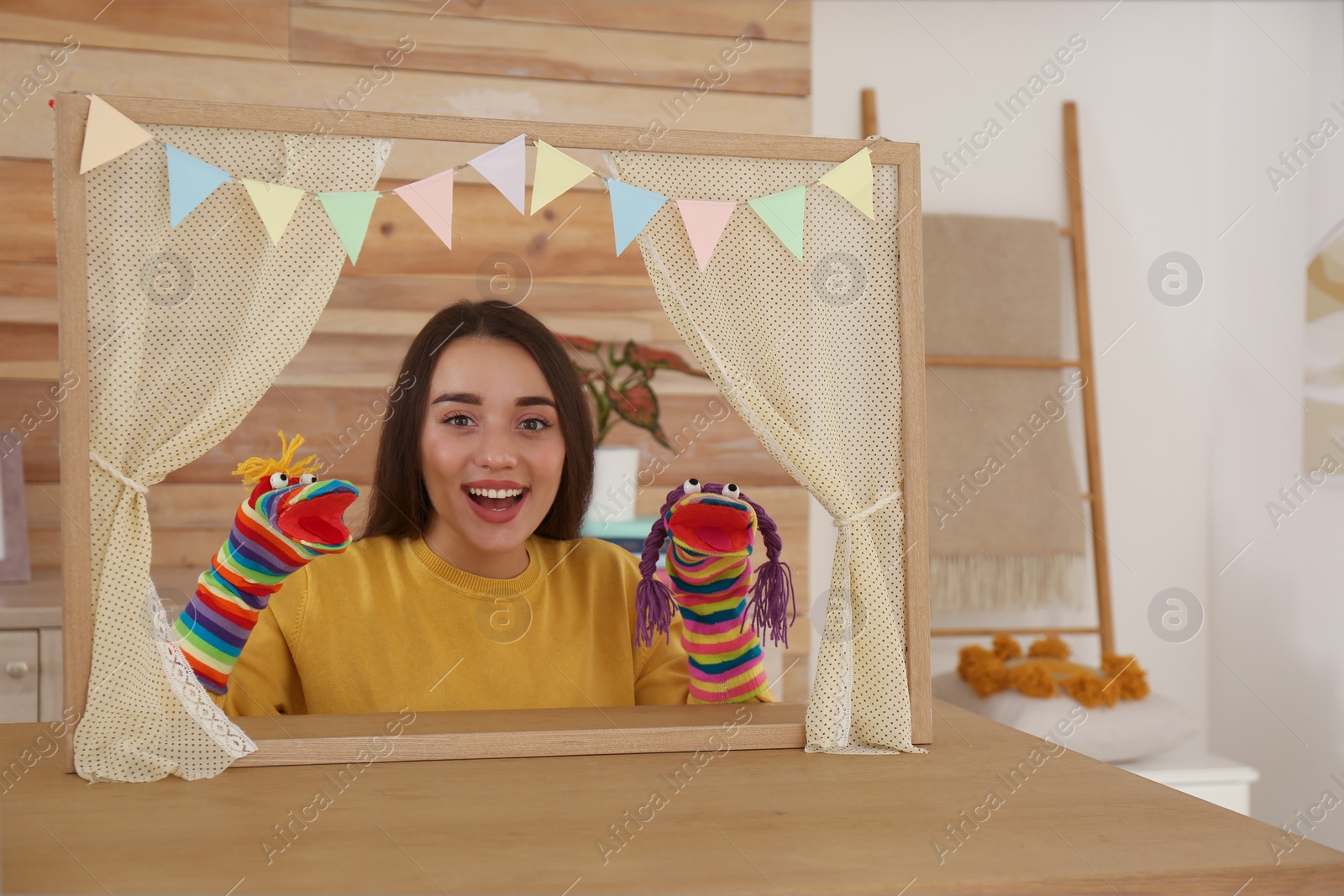 Photo of Young woman performing puppet show at home