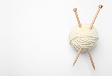 Photo of Soft yarn with knitting needles on white background, top view