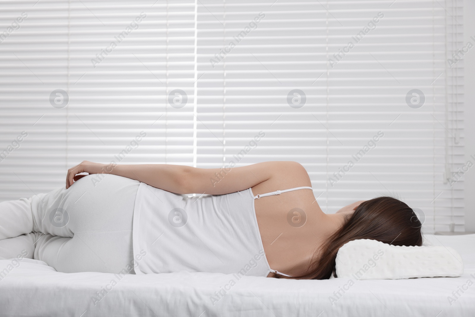 Photo of Woman sleeping on orthopedic pillow at home, space for text